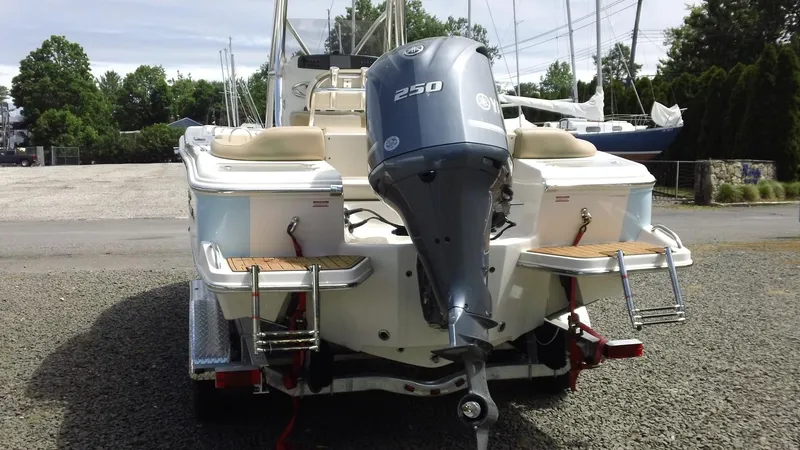 Slide: The Image of 2026 Pioneer 222 Islander boat with Yamaha 250 outboard motor, parked on gravel. - 23