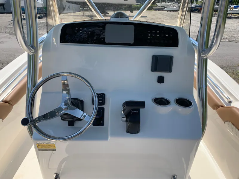 Slide: The Image of 2026 Pioneer 222 Islander boat console with steering wheel, controls, and cup holders. - 7