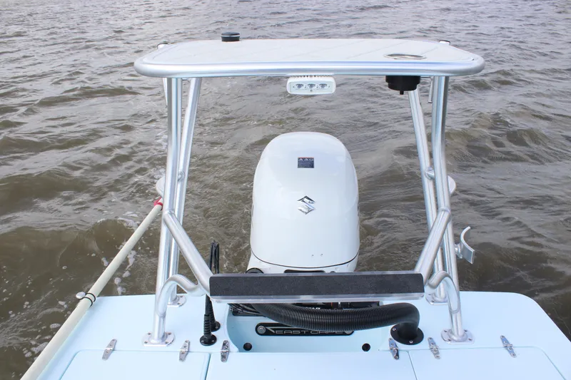 Slide: The Image of Open storage compartment on 2026 East Cape EVO 18V boat, near water. - 11