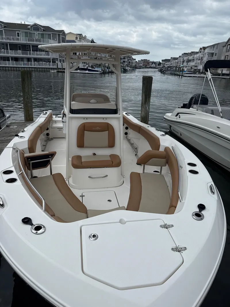 Slide: The Image of 2023 NauticStar 22L boat docked, featuring spacious seating and sleek design. - 10