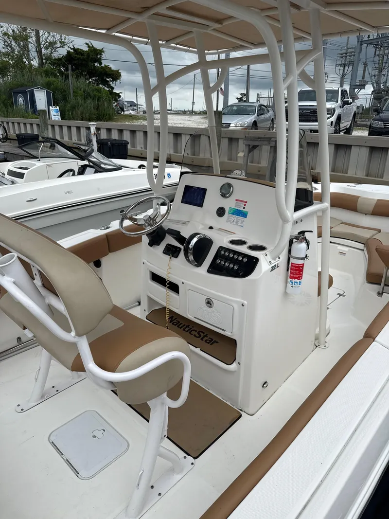 Slide: The Image of 2023 NauticStar 22L boat interior with helm, seating, and controls. - 7