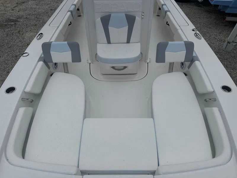 Slide: The Image of 2025 Robalo 246 Cayman boat interior with white cushioned seating and sleek design. - 10