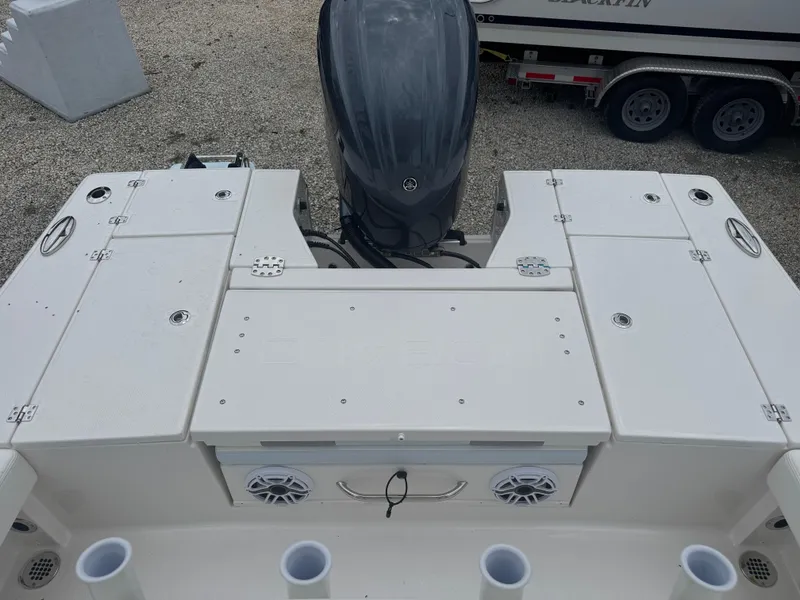 Slide: The Image of 2025 Robalo 246 Cayman boat deck with storage compartments and outboard motor. - 13