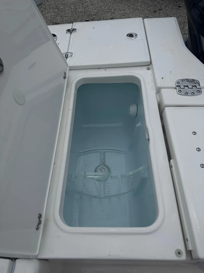 Slide: The Image of Livewell compartment on 2025 Robalo 246 Cayman boat, open lid, white interior. - 16