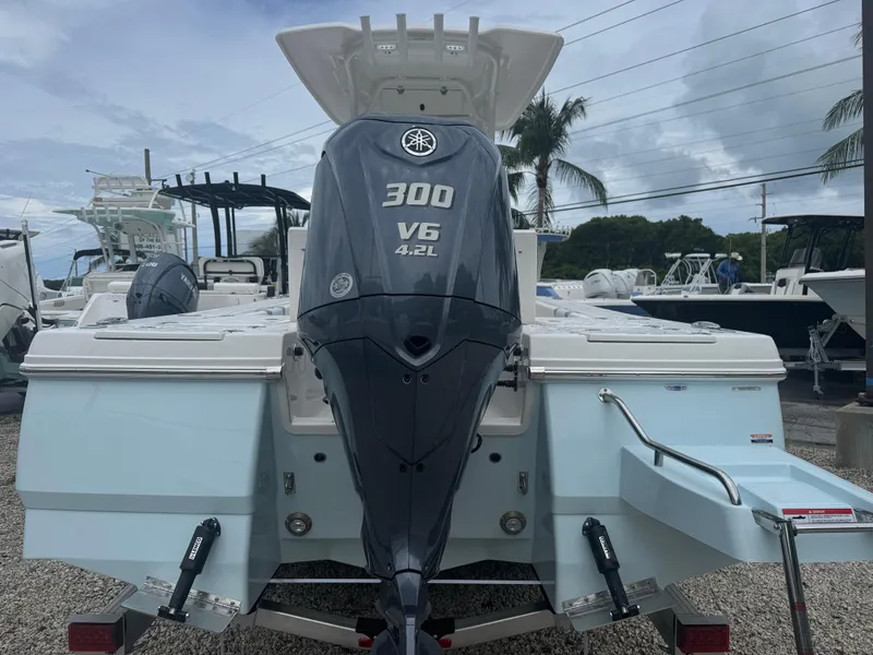 Slide: The Image of 2025 Robalo 246 Cayman boat with Yamaha 300 V6 engine, displayed outdoors. - 2