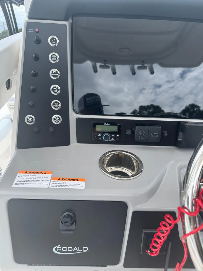 Slide: The Image of 2025 Robalo 246 Cayman boat dashboard with controls and warning labels. - 20