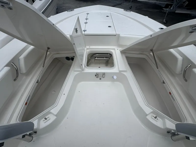 Slide: The Image of 2025 Robalo 246 Cayman boat with open storage compartments and sleek design. - 23