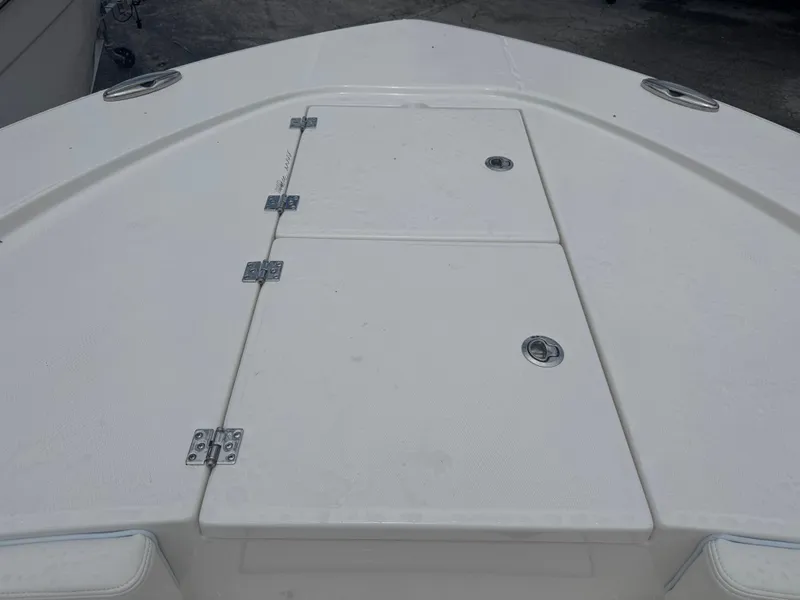 Slide: The Image of 2025 Robalo 246 Cayman boat deck with storage compartments and stainless steel hardware. - 24