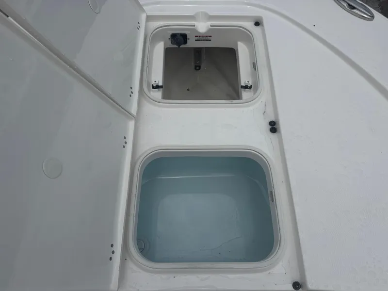 Slide: The Image of 2025 Robalo 246 Cayman boat storage compartments, open and empty, showcasing interior space. - 25