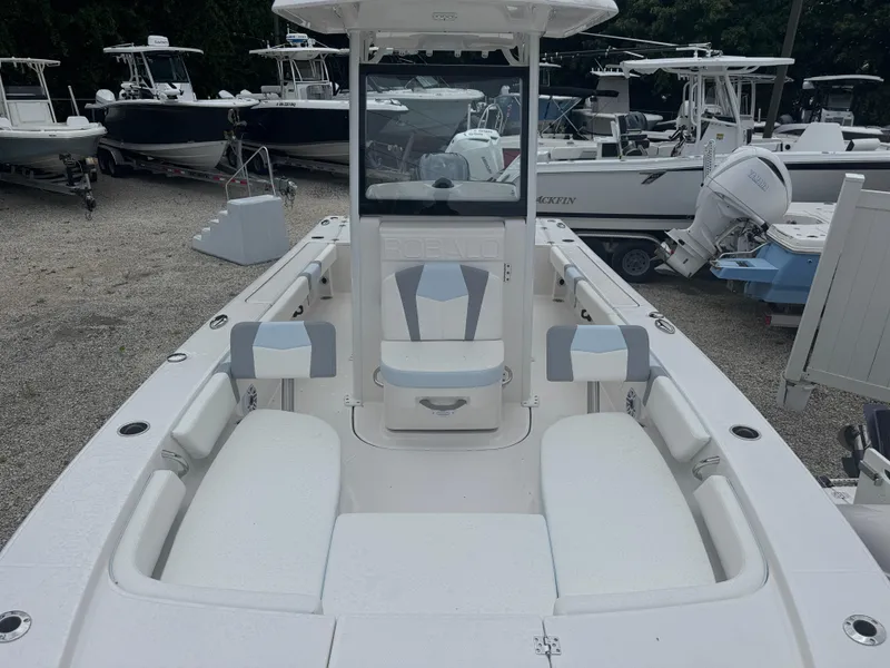 Slide: The Image of 2025 Robalo 246 Cayman boat interior with seating, docked among other boats. - 9