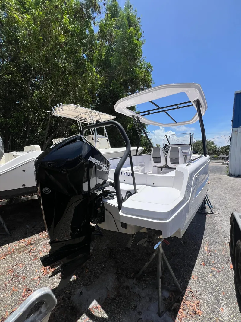 Slide: The Image of 2022 Axopar 22 T-Top boat with Mercury engine, parked outdoors under clear sky. - 18