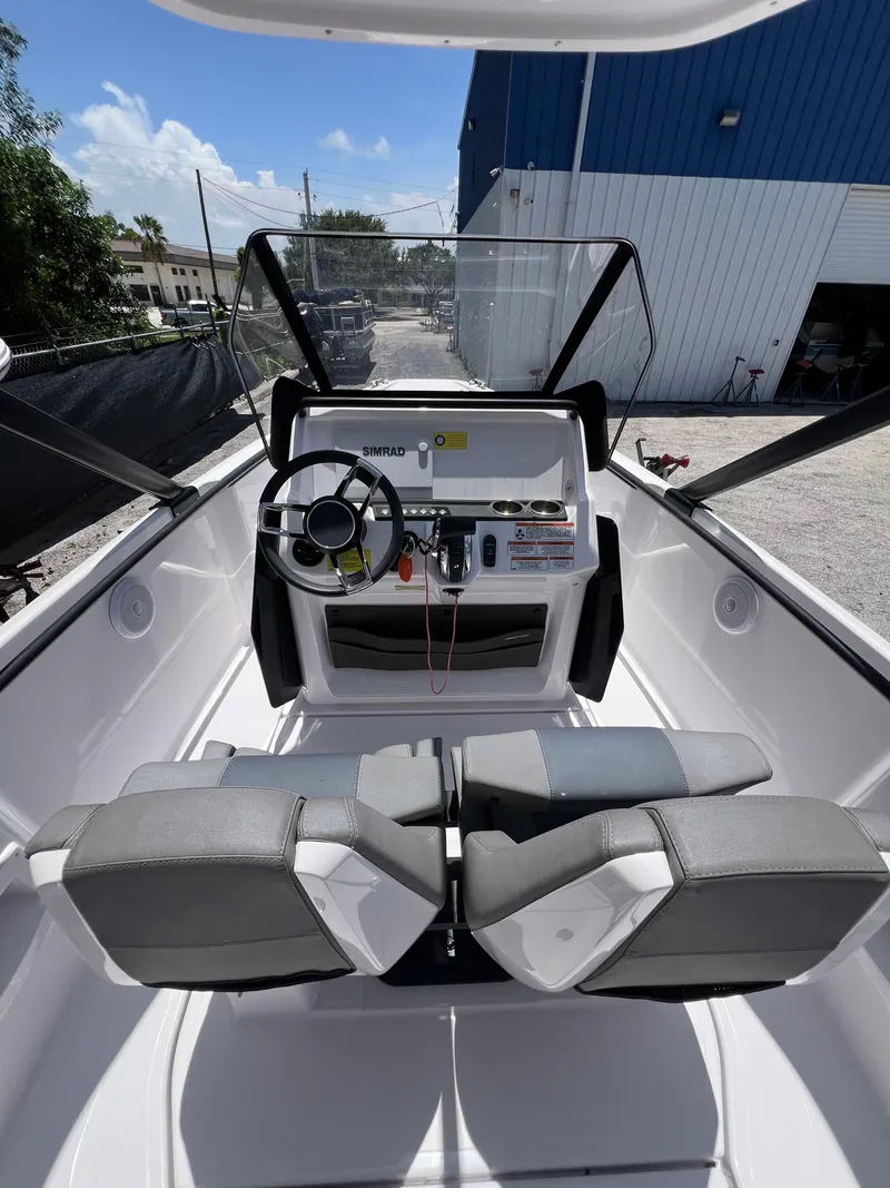 Slide: The Image of 2022 Axopar 22 T-Top boat interior with steering wheel and seating. - 2