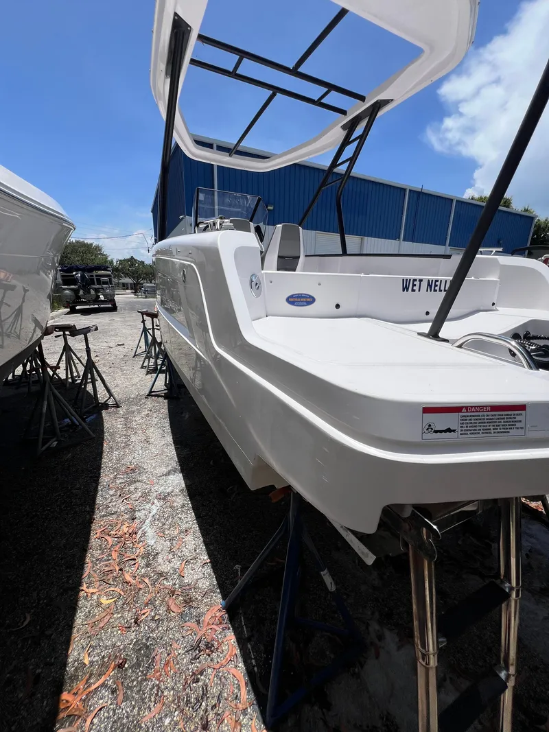 Slide: The Image of 2022 Axopar 22 T-Top boat on stands, outdoor storage, clear sky background. - 20