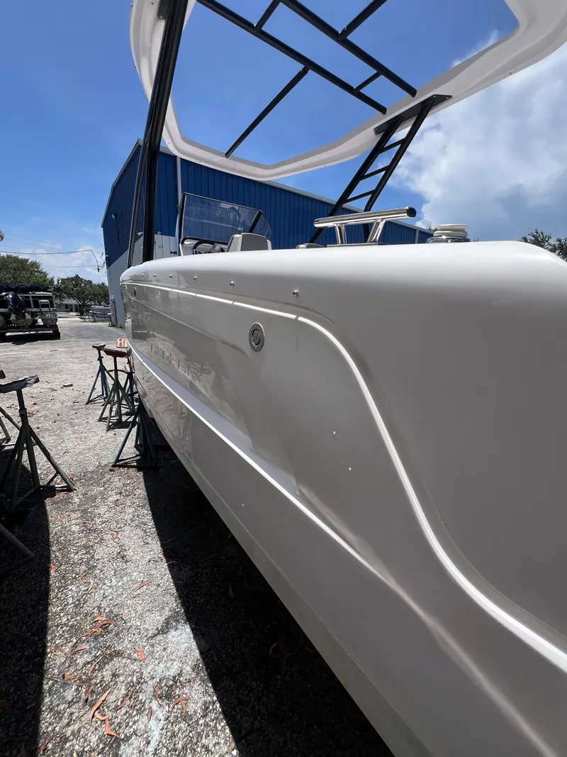 Slide: The Image of 2022 Axopar 22 T-Top boat in a sunny outdoor setting, showcasing sleek design. - 21