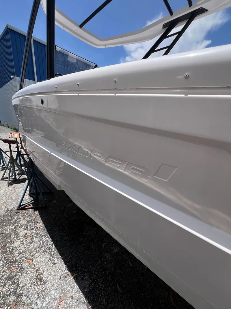 Slide: The Image of 2022 Axopar 22 T-Top boat side view under clear blue sky. - 22