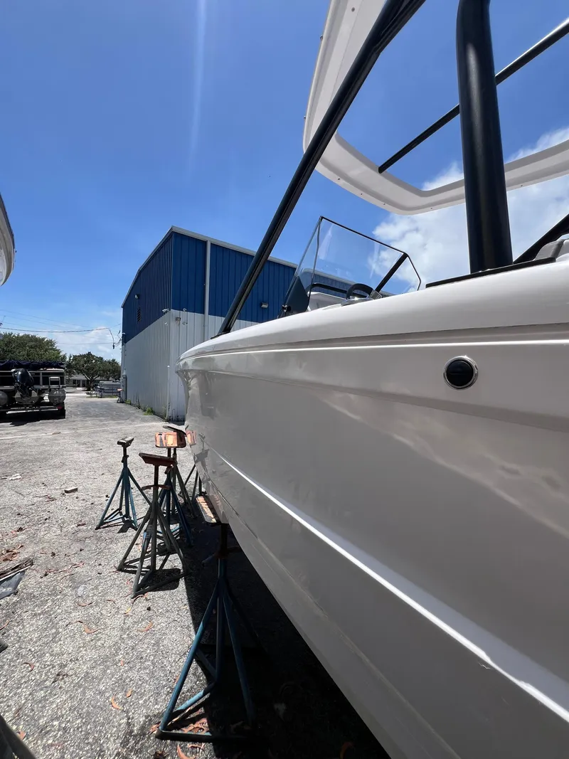 Slide: The Image of 2022 Axopar 22 T-Top boat on stands, outdoor storage, sunny day. - 23