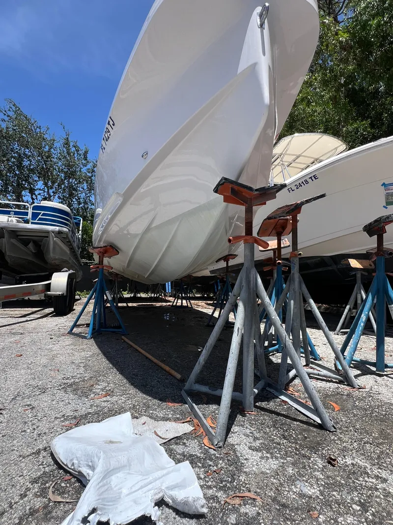 Slide: The Image of 2022 Axopar 22 T-Top boat on stands, outdoor storage, sunny day. - 25