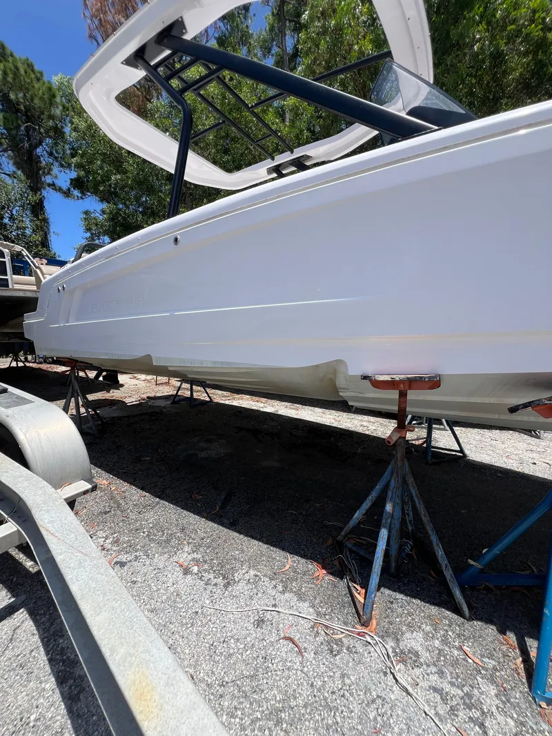 Slide: The Image of 2022 Axopar 22 T-Top boat on stands, viewed from the side, outdoors. - 29