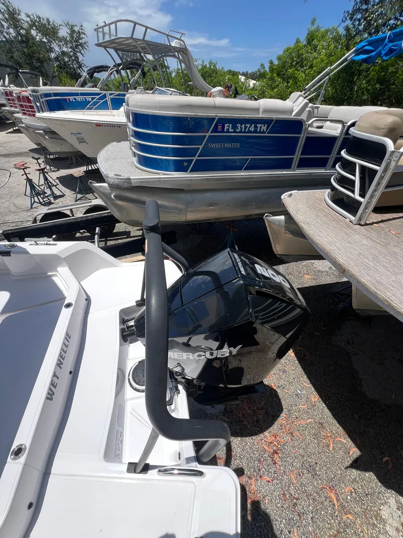 Slide: The Image of 2022 Axopar 22 T-Top boat with Mercury engine, docked among other boats. - 30