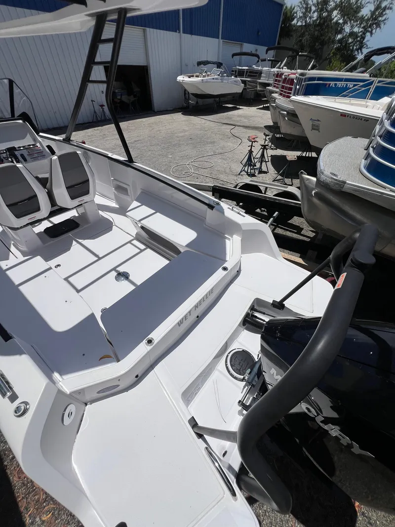 Slide: The Image of 2022 Axopar 22 T-Top boat interior with seating and motor, docked outdoors. - 31
