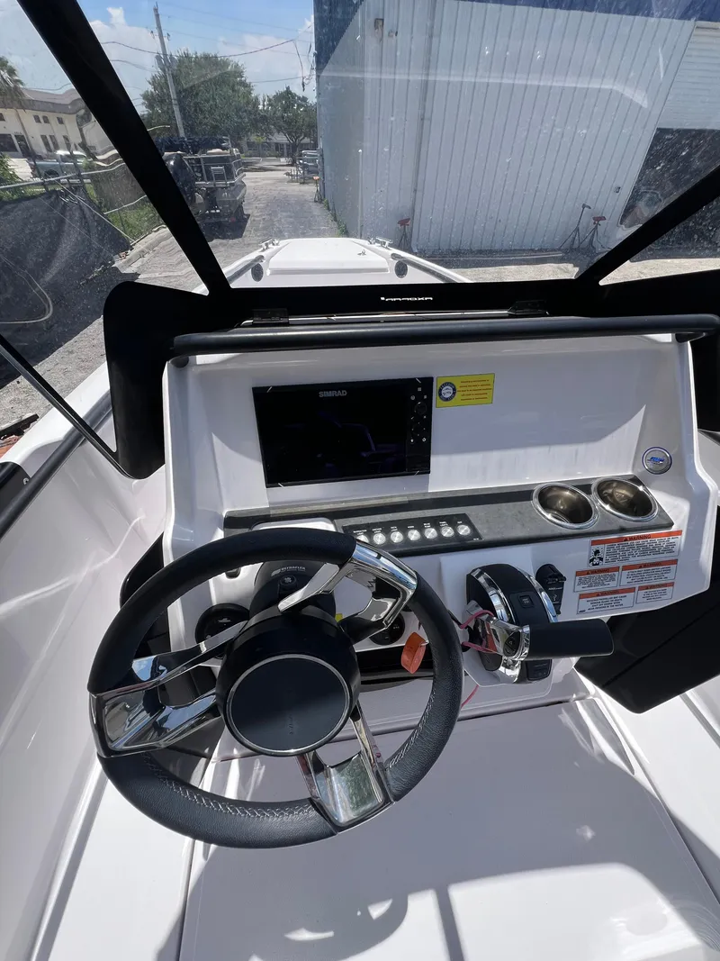 Slide: The Image of 2022 Axopar 22 T-Top boat dashboard with steering wheel and control panel. - 5