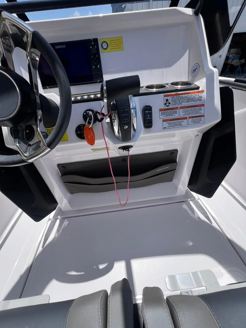 Slide: The Image of 2022 Axopar 22 T-Top boat dashboard with steering wheel and controls. - 6