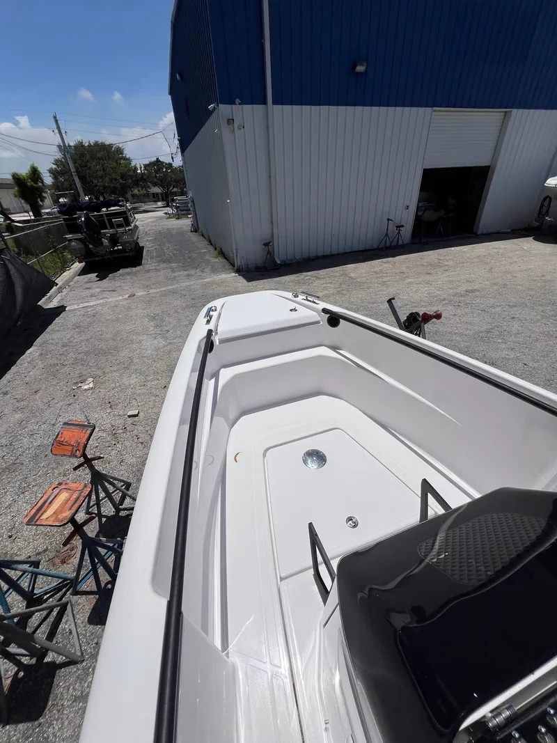 Slide: The Image of 2022 Axopar 22 T-Top boat parked outside a blue warehouse. - 7