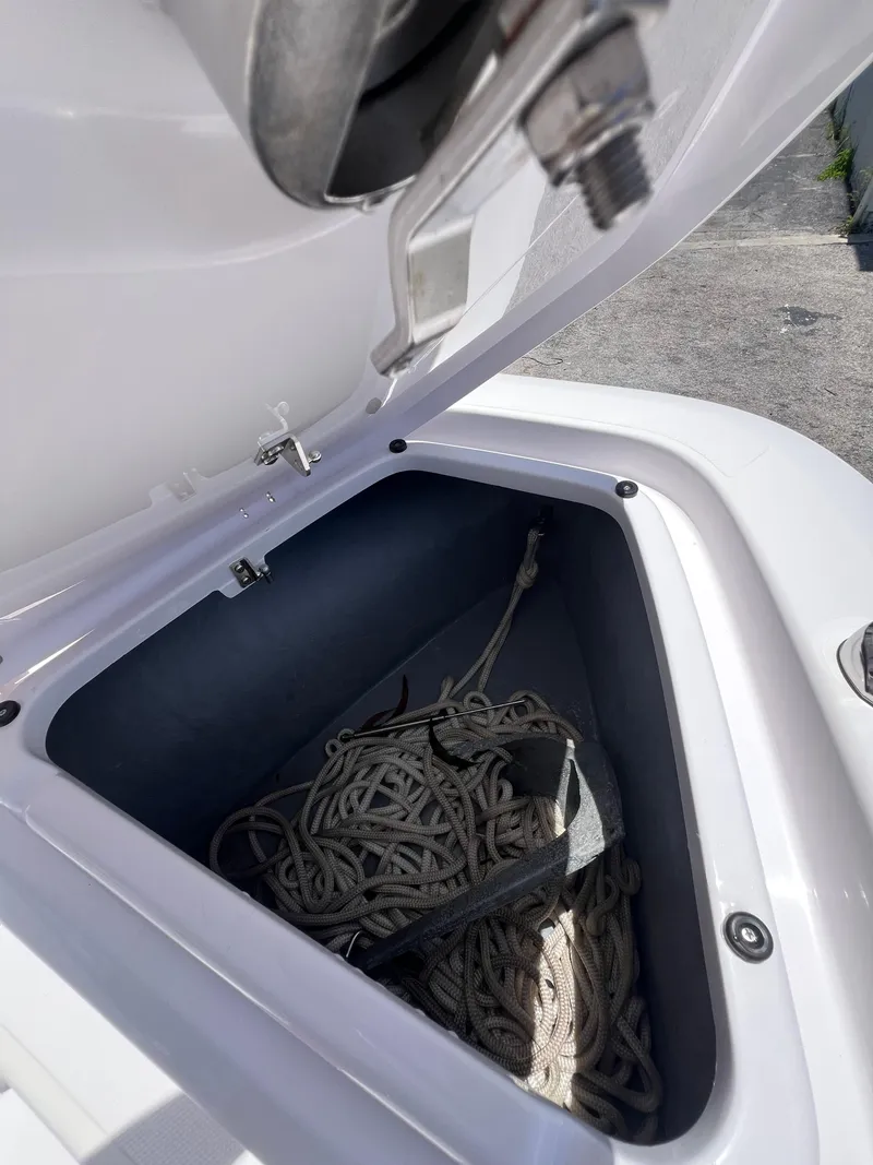 Slide: The Image of Open storage compartment on 2022 Axopar 22 T-Top boat with coiled rope inside. - 8