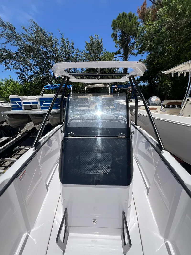 Slide: The Image of 2022 Axopar 22 T-Top boat with sleek design, viewed from the front under clear blue sky. - 9