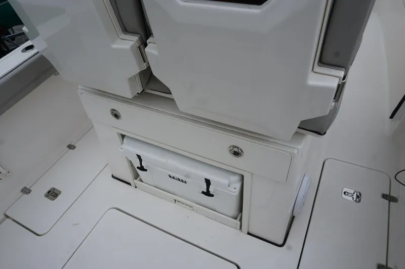 Slide: The Image of 2024 Pursuit S 248 Sport boat interior with storage compartment and cooler. - 10