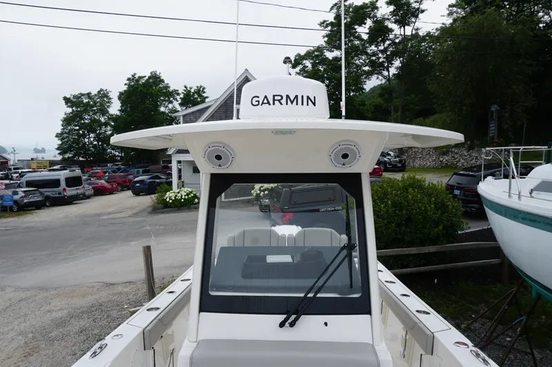 Slide: The Image of 2024 Pursuit S 248 Sport boat with Garmin equipment, docked near parked cars and greenery. - 13