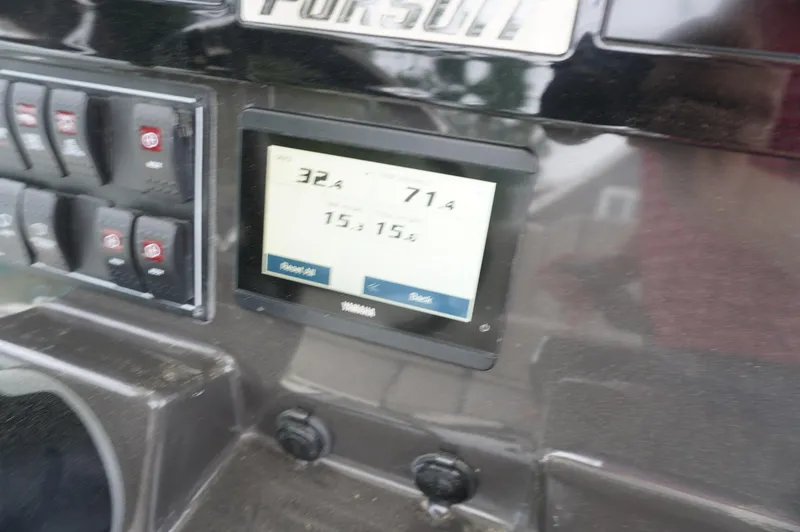 Slide: The Image of 2024 Pursuit S 248 Sport dashboard with digital display and control switches. - 15