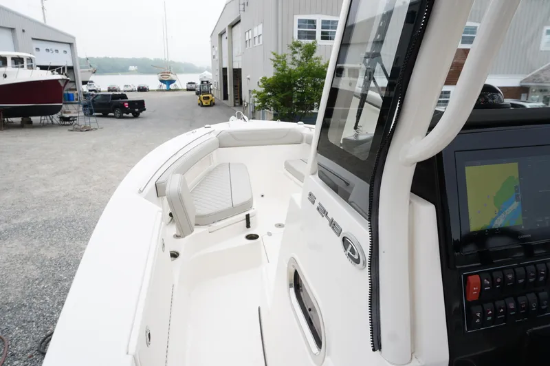 Slide: The Image of 2024 Pursuit S 248 Sport boat interior with navigation system, docked at a marina. - 17