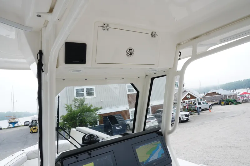 Slide: The Image of 2024 Pursuit S 248 Sport boat interior with navigation system and marina view. - 18