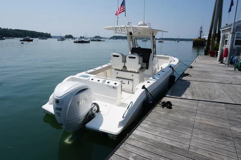 Slide: The Image of 2024 Pursuit S 248 Sport boat docked with Yamaha engine, calm waters, and clear sky. - 2