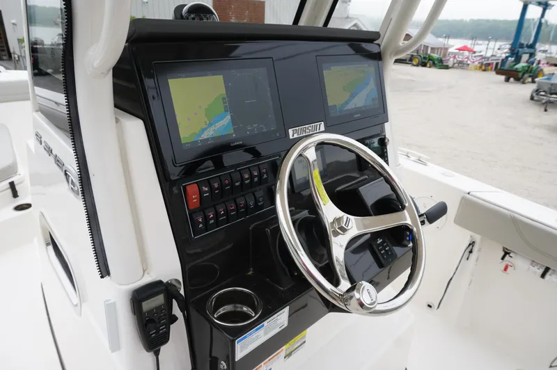 Slide: The Image of 2024 Pursuit S 248 Sport boat dashboard with steering wheel and navigation screens. - 4