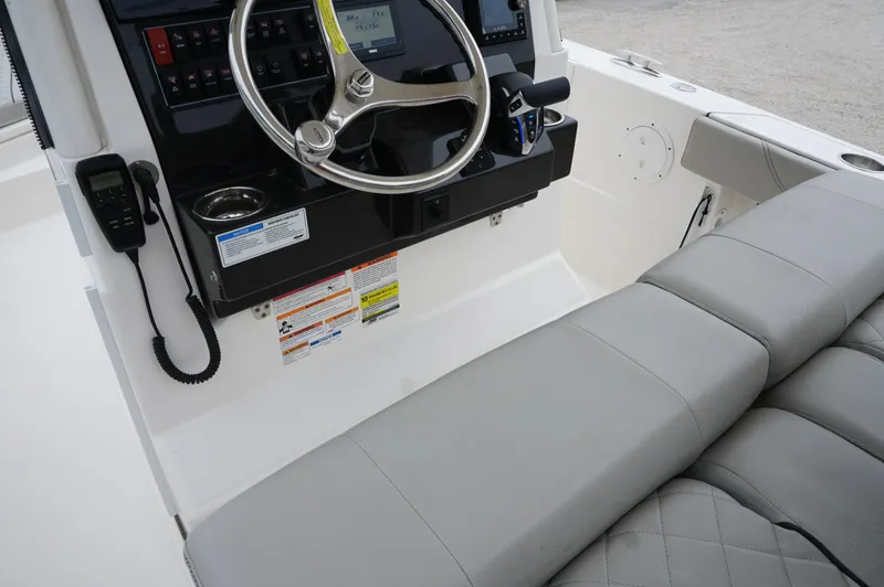 Slide: The Image of 2024 Pursuit S 248 Sport boat cockpit with steering wheel and cushioned seating. - 9