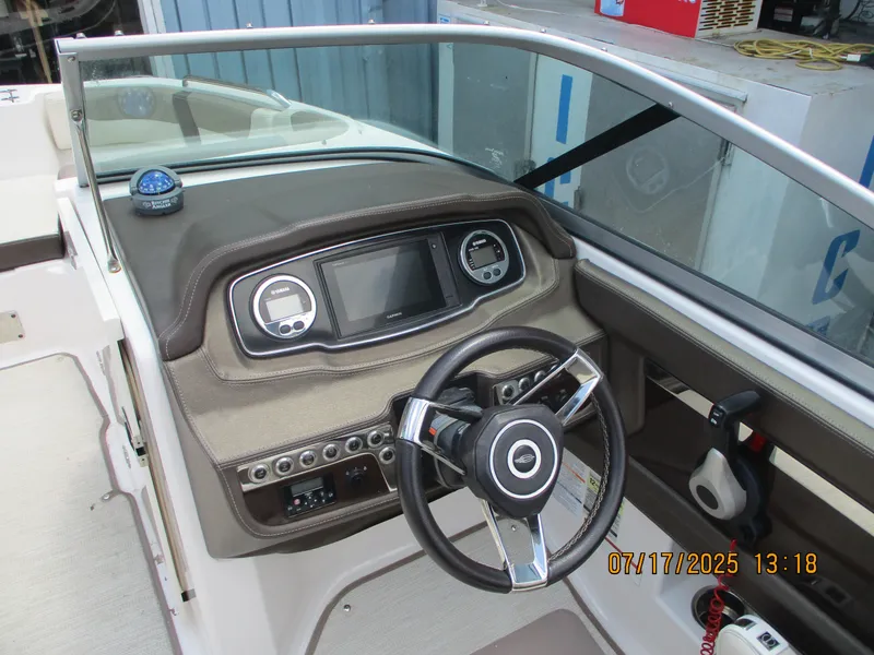 Slide: The Image of 2019 Chaparral 210 Suncoast boat dashboard with steering wheel and control panel. - 11