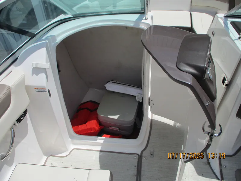 Slide: The Image of 2019 Chaparral 210 Suncoast boat interior with storage compartment and safety equipment. - 13