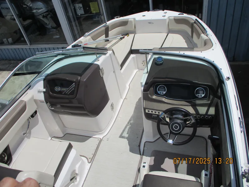 Slide: The Image of 2019 Chaparral 210 Suncoast boat interior with steering wheel and seating area. - 2