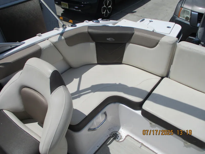 Slide: The Image of 2019 Chaparral 210 Suncoast boat interior with beige and brown seating. - 21