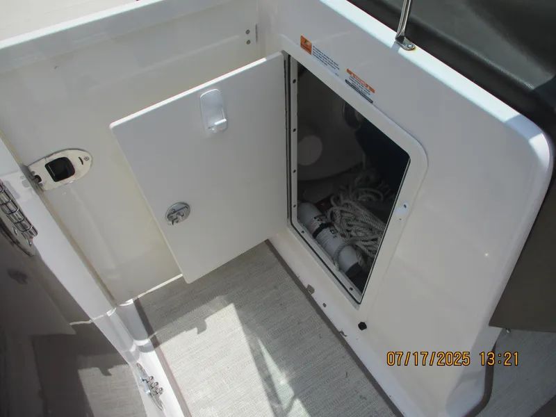 Slide: The Image of Open storage compartment on 2019 Chaparral 210 Suncoast boat, showing ropes and equipment. - 24