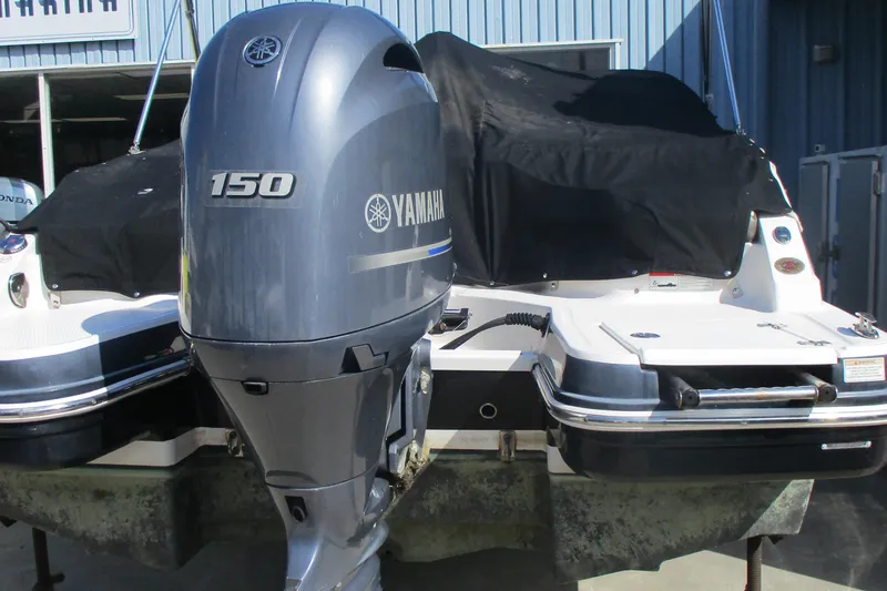 Slide: The Image of 2019 Chaparral 210 Suncoast boat with Yamaha 150 outboard motor, covered and docked. - 9
