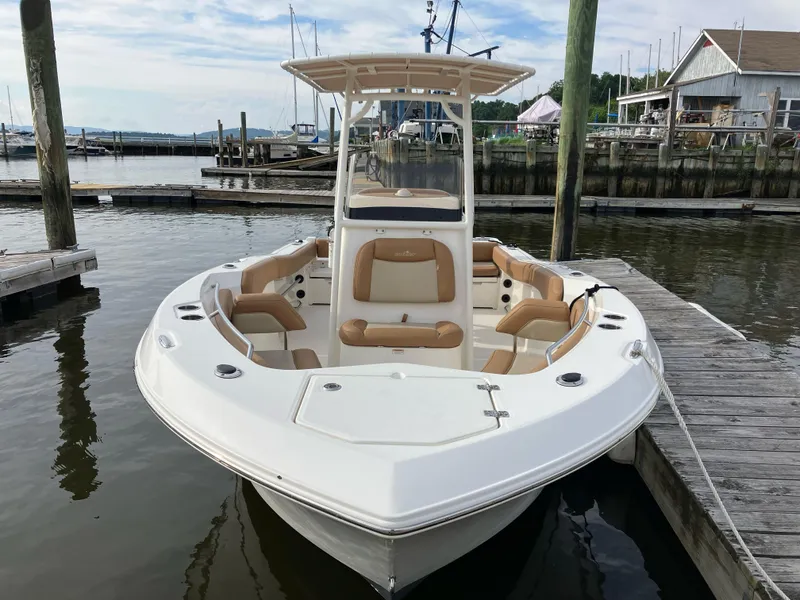 Slide: The Image of 2023 NauticStar 22L boat docked at marina, featuring sleek design and comfortable seating. - 3