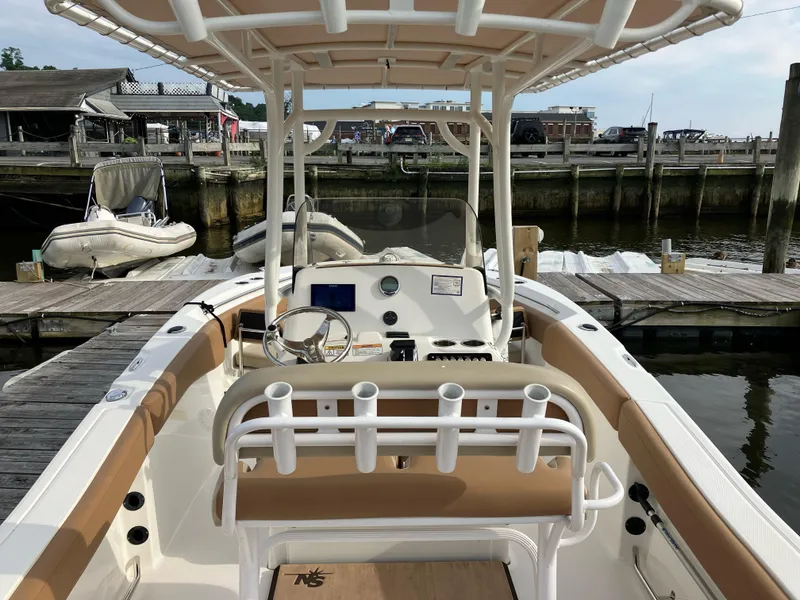 Slide: The Image of 2023 NauticStar 22L boat docked, featuring a spacious helm and seating area. - 5