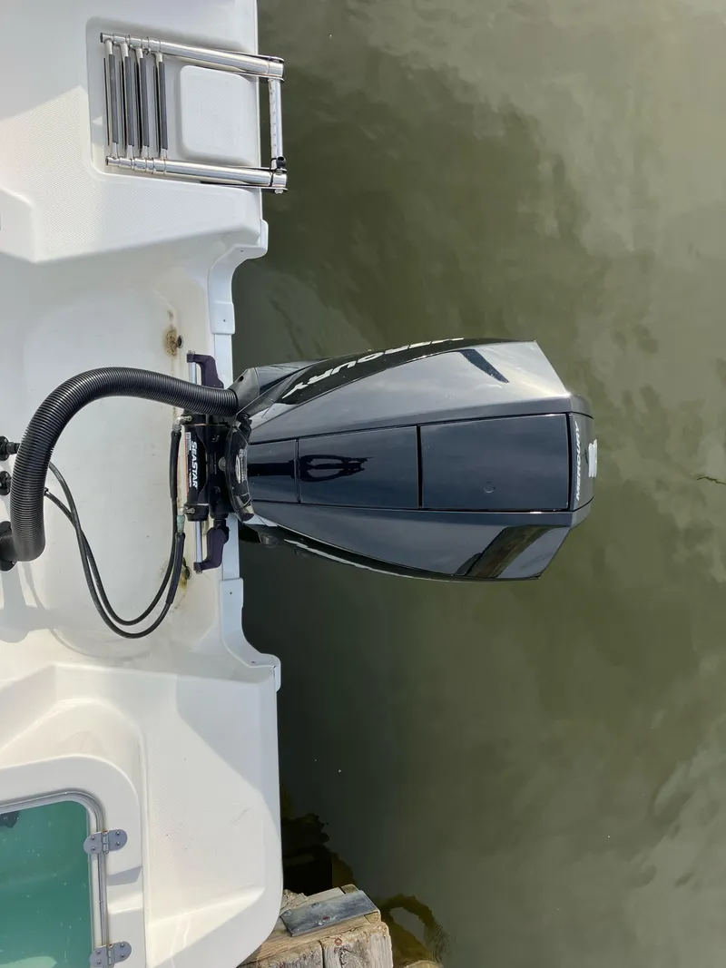 Slide: The Image of 2023 NauticStar 22L boat with outboard motor and swim ladder on calm water. - 7