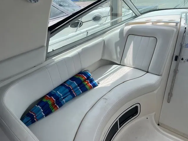 Slide: The Image of White leather seating on 1998 Sea Ray 290 Sundancer boat with colorful striped towel. - 11