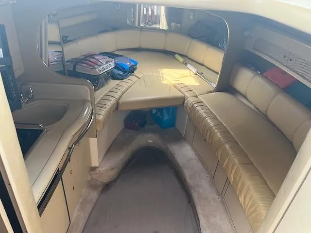 Slide: The Image of Interior of 1998 Sea Ray 290 Sundancer boat with beige seating and compact kitchenette. - 12