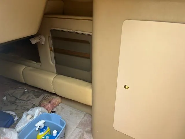 Slide: The Image of 1998 Sea Ray 290 Sundancer cabin interior with beige upholstery and storage compartments. - 16