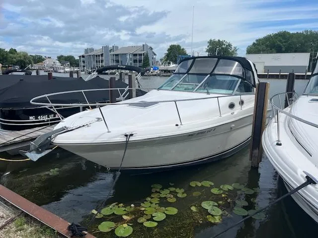 Slide: The Image of 1998 Sea Ray 290 Sundancer docked in a marina with lily pads nearby. - 2